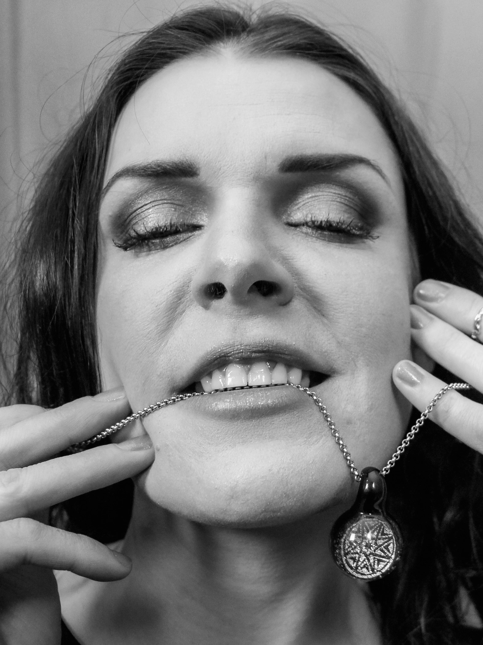 Close-up portrait of a woman wearing a delicate pendant chain