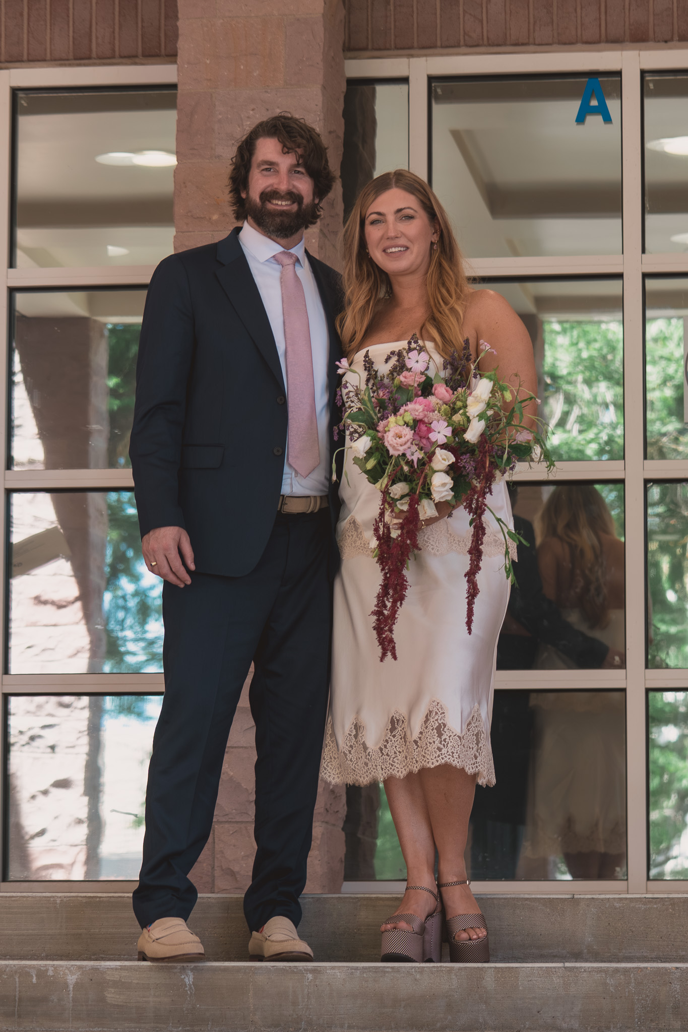 Urban Denver elopement photographer — newlyweds smiling on the courthouse steps