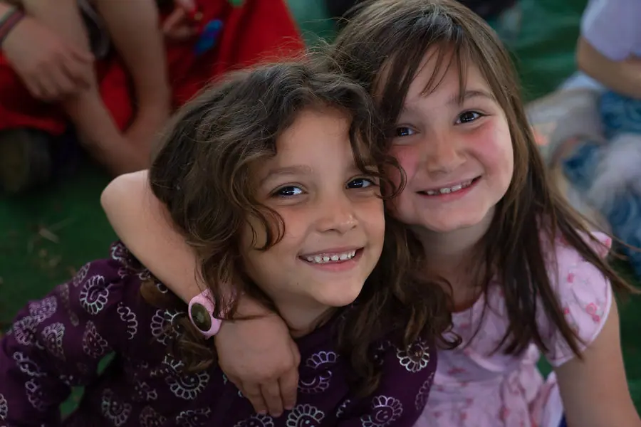 Two girls hugging and grinning at the camera
