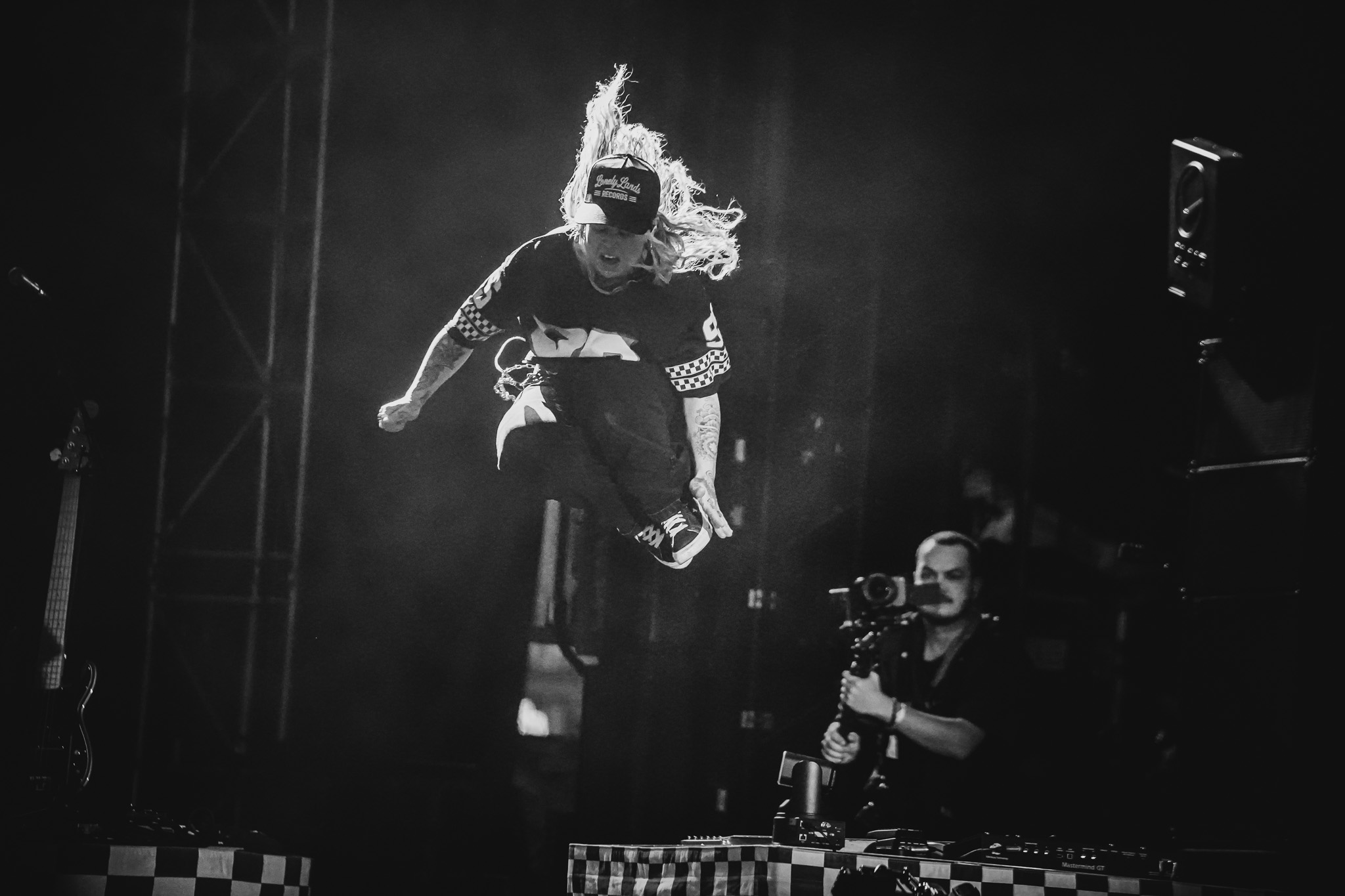Guitarist jumping from a stage riser during a live performance
